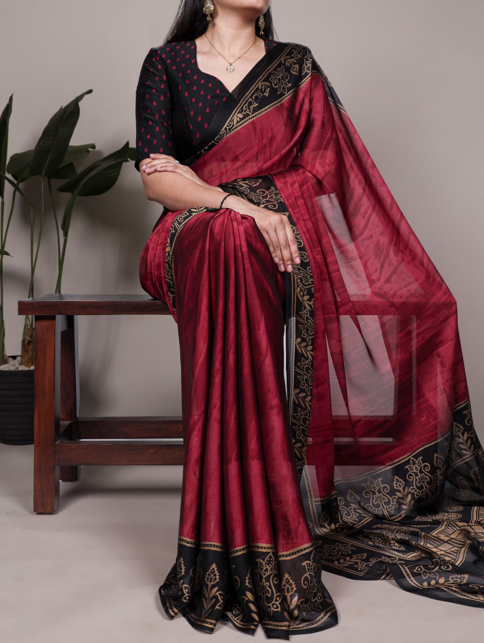 Maroon Rangoli Silk Printed Saree with Black and Gold Printed Border.