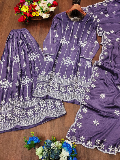 Purple embroidered outfit with white patterns on a wooden surface with flowers.